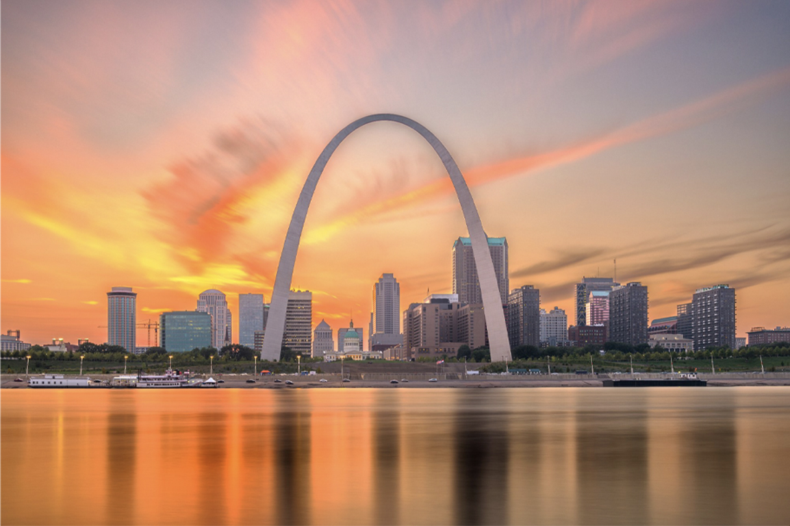 a sunset view of the city with big white arch