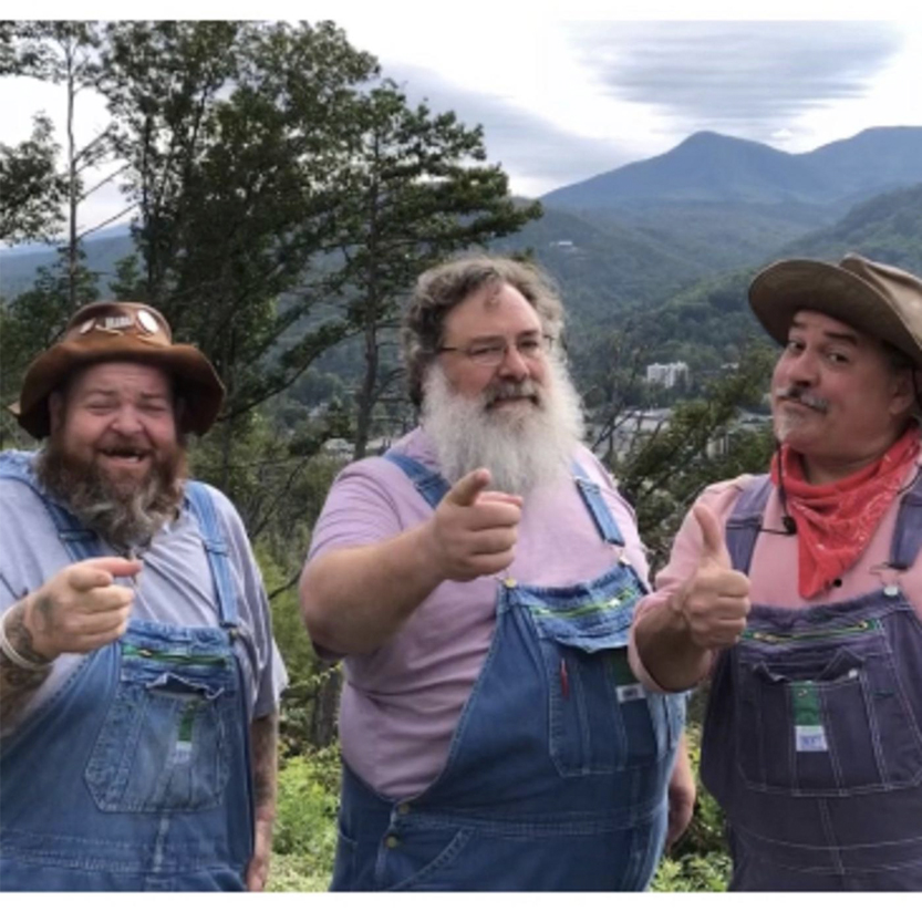 three man in overalls pointing fingers