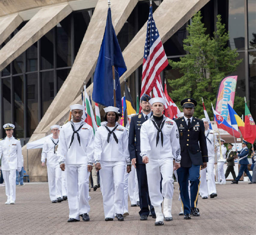 a group of people in navy uniform are walking